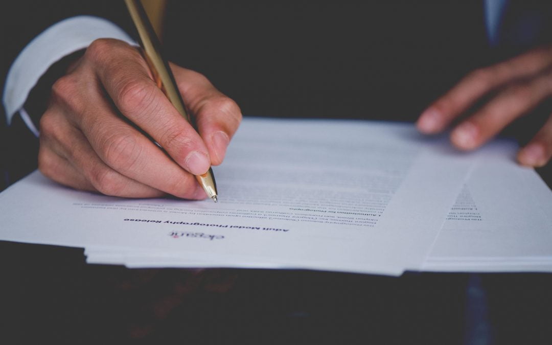 Hand signing a legal document.